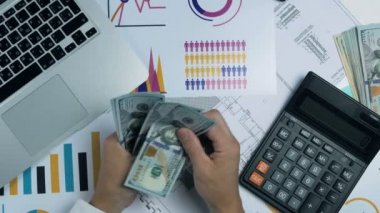 İşadamı yüz dolar faturaları masanın üzerine ortaya konuyor. Ateş yukarıda Üstten Görünüm.