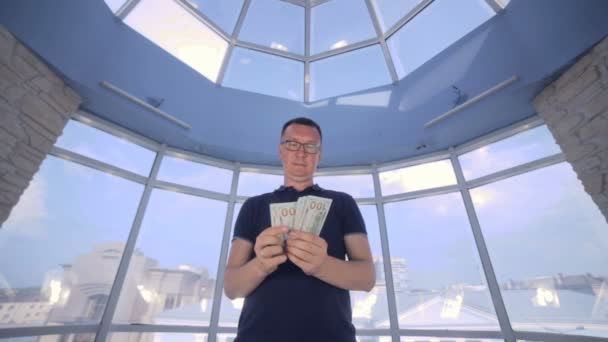 Jeter de l'argent dans l'air. Un homme d'affaires nous comptant des dollars, le jetant en l'air . — Video