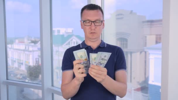 Un homme confiant et sérieux compte et montre de l'argent, les dollars américains dans la caméra . — Video