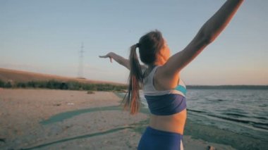 İnce bir rakam ile genç kız denizde jimnastik güneş doğarken devreye girer. Tanınmayan siluet.