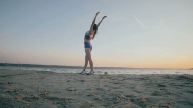 İnce bir rakam ile genç kız denizde jimnastik güneş doğarken devreye girer. Tanınmayan siluet.
