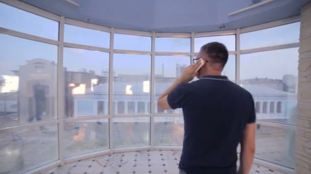 Jonge man in moderne lichte kantoren praten aan de telefoon. Steadicam schot. — Stockvideo