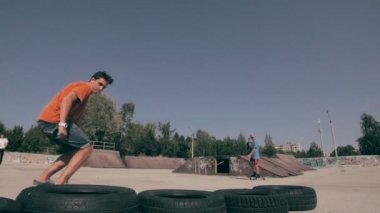 Bir şehir paten parkta atlama kaykaycı. Skow hareket. Steadicam ateş.