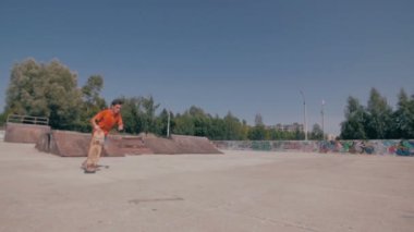 Bir şehir paten parkta atlama kaykaycı. Skow hareket. Steadicam ateş.