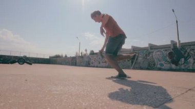 Bir şehir paten parkta atlama kaykaycı. Skow hareket. Steadicam ateş.