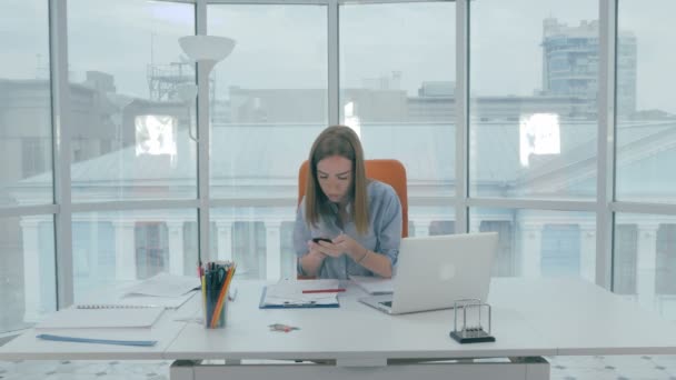 Joven atractiva mujer feliz en la oficina recibe un mensaje de texto, ser feliz . — Vídeos de Stock