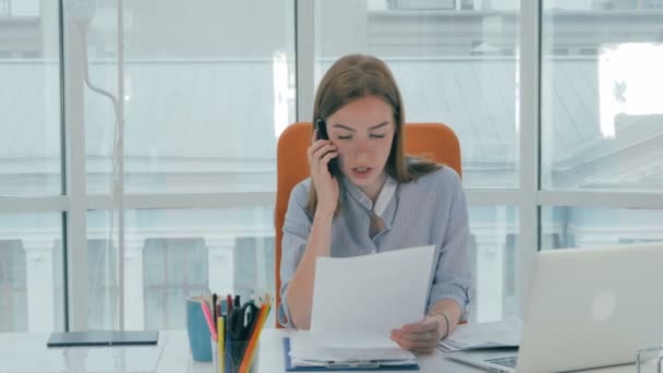 Bilgisayarda çalışarak ve çağrı merkezi telefonda konuşurken kadın resepsiyonist. — Stok video