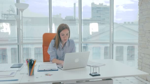 Joven atractiva mujer de negocios que tiene dolor de cabeza repentino en la oficina. Concepto de salud y estrés . — Vídeo de stock