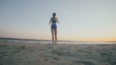 İnce bir rakam ile genç kız denizde jimnastik güneş doğarken devreye girer. Tanınmayan siluet.