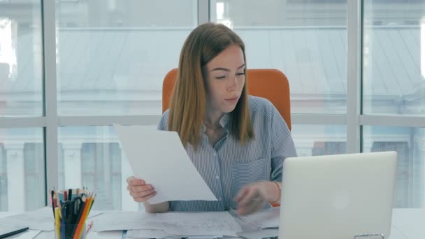 Junge attraktive beschäftigte Frau arbeitet mit Computer, Papiere im Büro. — Stockvideo