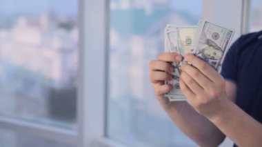 Parlak panoramik pencerede dolar sayan adam. Para tasarrufu, ekonomi, nakit kavramı.