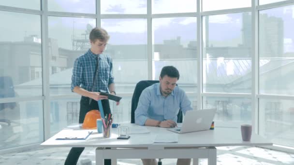 Directeur discuter du projet avec l'employé, donne des conseils, en utilisant une tablette numérique dans le nouveau bureau moderne . — Video