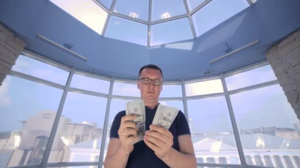 Uomo sicuro, serio che conta e mostra soldi, dollari USA nella macchina fotografica . — Video Stock