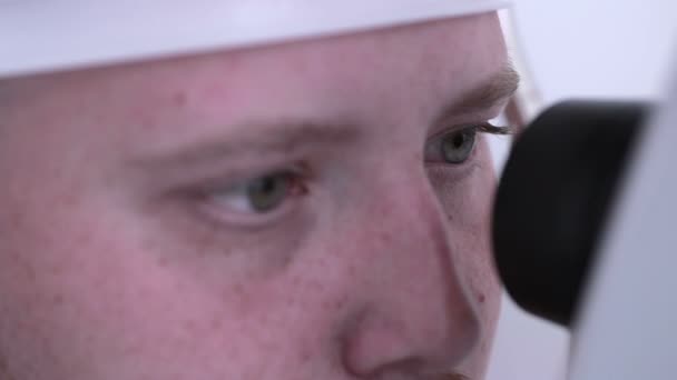 Mannelijke patiënt op een onderzoek van het oog. Medische aanwezigheid bij de optometrist in een lichte moderne kliniek. — Stockvideo