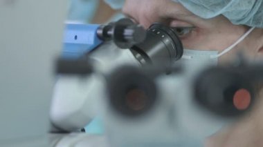 İlaç endüstrisi laboratuarda çalışan ve mikroskop seyir tanınmaz halde kadın araştırmacı.