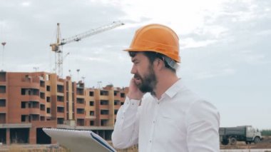 İnşaat alanında cep telefonuyla konuşurken mimar.