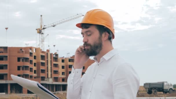 Architekt telefoniert auf einer Baustelle. — Stockvideo