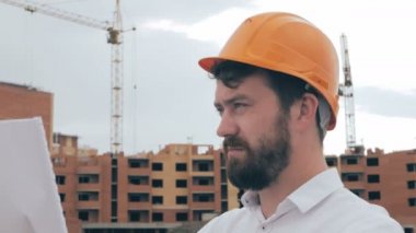 Profesyonel mimar planları, inşaat alanında bakarak.