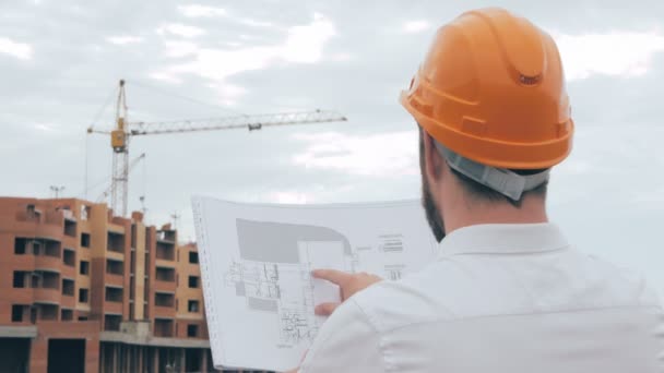 Професійний архітектор, який дивиться креслення на будівельному майданчику . — стокове відео