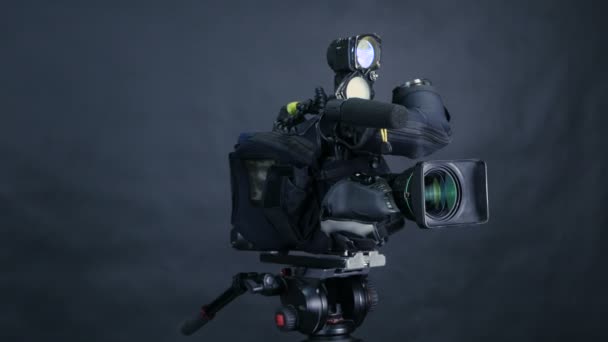 Professionele digitale videocamera, camcoder geïsoleerd op een zwarte achtergrond in tv srudio. — Stockvideo