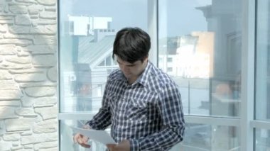 Genç işadamı belgeleri, kağıtları evde pencere tarafından atma boğulmuş.