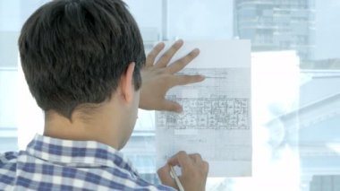 Modern bir ofis planı üzerinde çalışan mühendis.