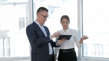 Grup mühendis ve mimar tablet modern parlak ofis planı tartışmak.