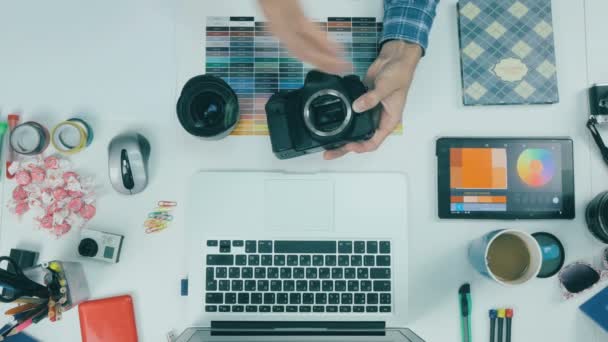 Görünümünün üzerinde. Yaratıcı ajansı masasında çalışan fotoğrafçı. — Stok video