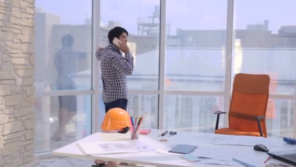 Giovane architetto che lavora con cianografie in ufficio . — Video Stock