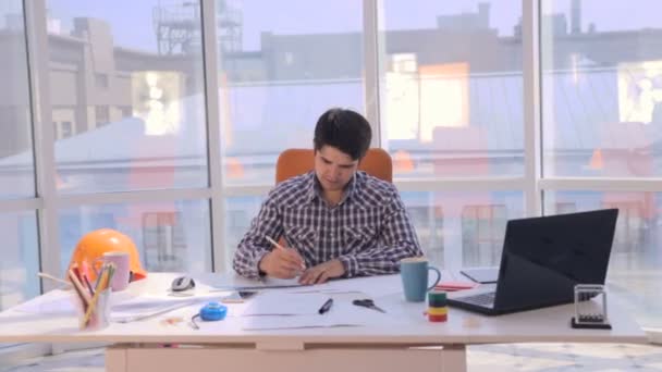 Jeune architecte travaillant avec des plans dans le bureau . — Video