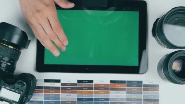 Ansicht von oben. Ein Mann arbeitet in einem Designstudio an einem Green-Screen-Tablet. Kreativer Hintergrund. — Stockvideo