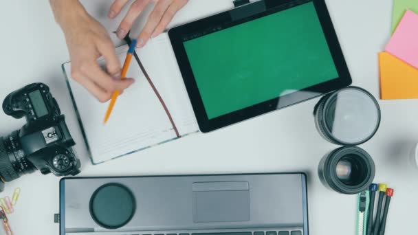 Vista dall'alto. Uomo che lavora su tablet schermo verde in uno studio di design. Sfondo creativo . — Video Stock