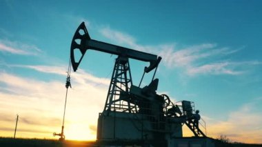 Petrol pompalama merdivenlerinde duran iki işçi iş konularını tartışıyor
