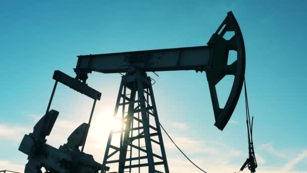 Låg vinkel skott av olja pumpjack som arbetar mot blå himmel — Stockvideo