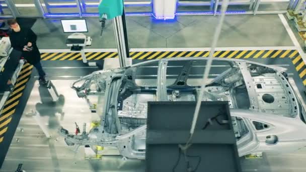 Auto assemblagelijn, auto-industrie concept. Karkas van een auto in uitvoering in een fabriekseenheid — Stockvideo