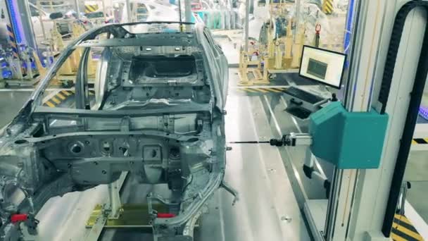 Araba üretim hattı, otomobil endüstrisi konsepti. Metal bir otomobil leşi olan fabrika ünitesi çalışıyor. — Stok video