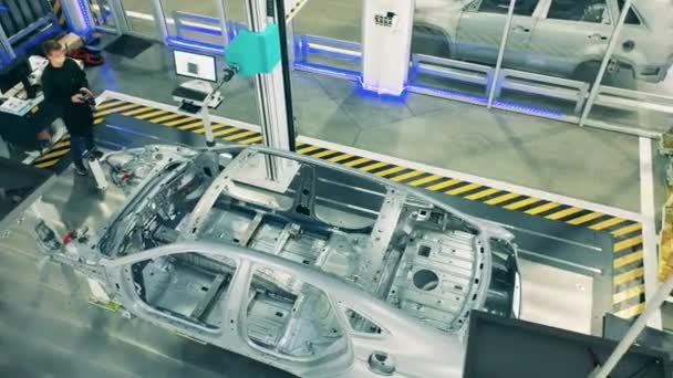 Metallstomme från en oavslutad bil i fabrikslokalerna. Biltransportör, bilfabrik. — Stockvideo