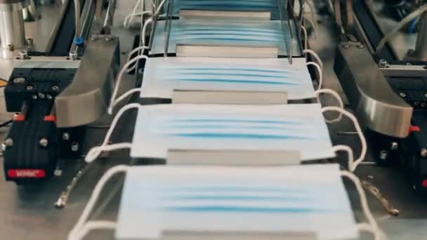 Medical masks moving along a conveyor at a face mask production factory — Stock Video