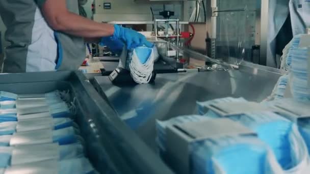 Пакеты с масками для лица загружаются в упаковочную машину — стоковое видео