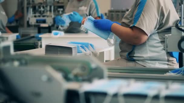 Vrouwelijke werknemers stapelen maskers op in een medisch masker fabriek — Stockvideo