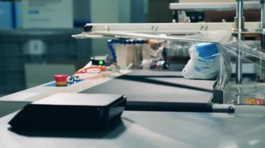 Tıbbi profesyonel yüz maskelerini paketleme makinesine yüklüyor.