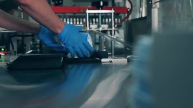 Sağlık çalışanı yüz maskelerini bir makine kullanarak paketliyor.