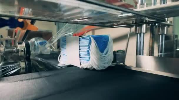Moderne gezichtsmasker verpakkingsmachine bij een medisch masker fabriek. Sluiten. — Stockvideo