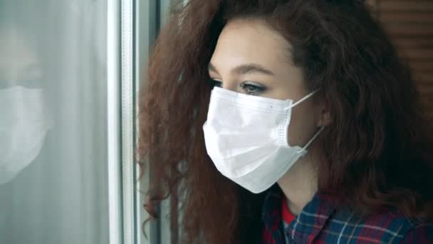 Schöne Dame mit Gesichtsmaske schaut ins Fenster — Stockvideo