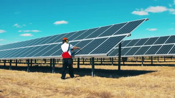 Pracownik konserwacji paneli słonecznych na farmie energii słonecznej. Pracownicy elektrowni słonecznych, koncepcja przemysłu energii słonecznej. — Wideo stockowe