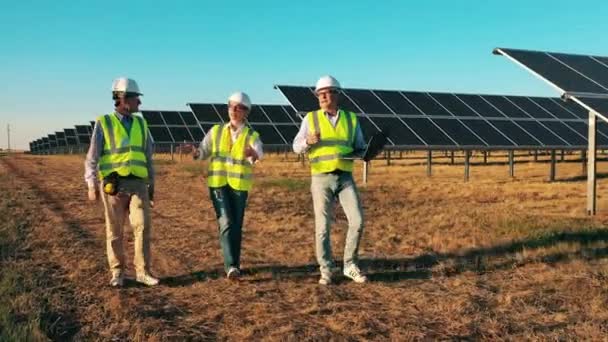 Profesjonalni inżynierowie, pracownicy chodzący po elektrowniach słonecznych. Pracownicy elektrowni słonecznych, koncepcja przemysłu energii słonecznej. — Wideo stockowe