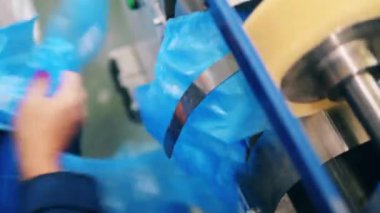 Taşıyıcı polietilen torbaları bırakıyor. Polietilen üretim fabrikası taşıyıcısı.