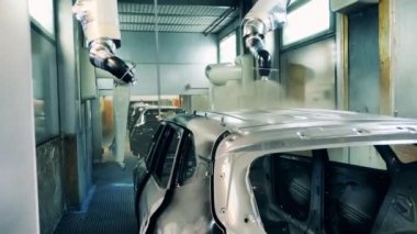 Otomotiv ressamı robotlar araba gövdesi boyuyor