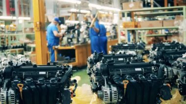 Arka planda araba işçileri olan otomobil motorlarının yakın çekim görüntüleri.