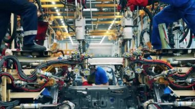 Birkaç fabrika işçisi araba fabrikasında bir araba cesedi kaynaklıyor.